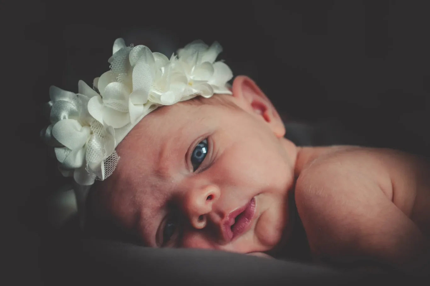 Bebé recién nacido durmiendo con cinta en la cabeza en sesión de fotos en Tenerife