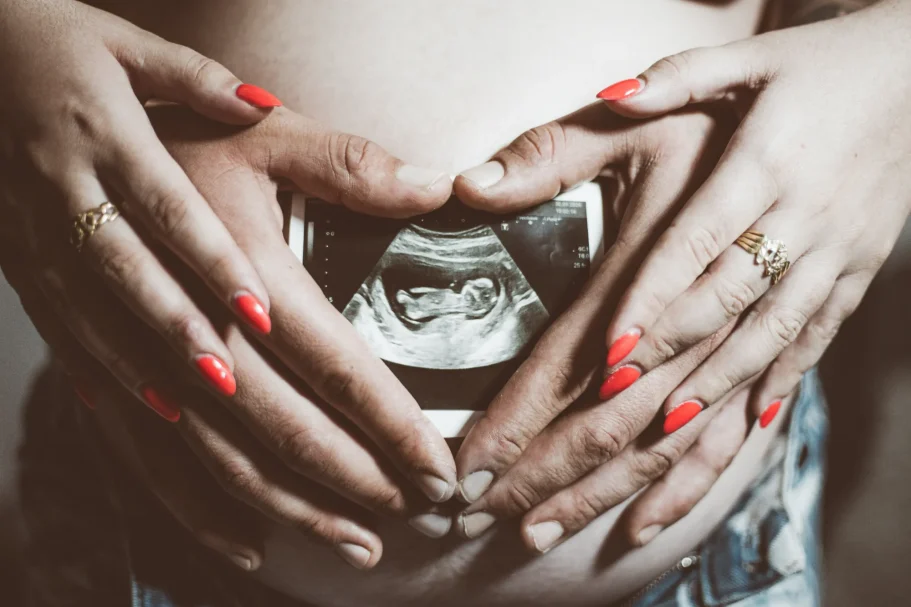 Fotos Embarazo y maternidad en Tenerife con manos de papás sosteniendo una ecografía de embarazo