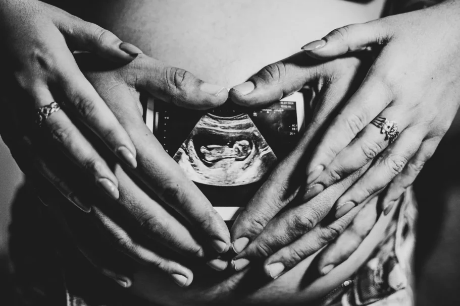 Fotos Embarazo y maternidad en Tenerife con manos de papás sosteniendo una ecografía de embarazo